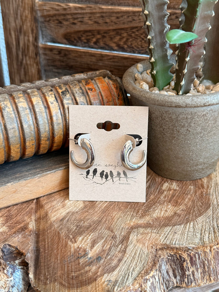 Silver half-curved hoop stud earrings, round posts, polished metal on backing card