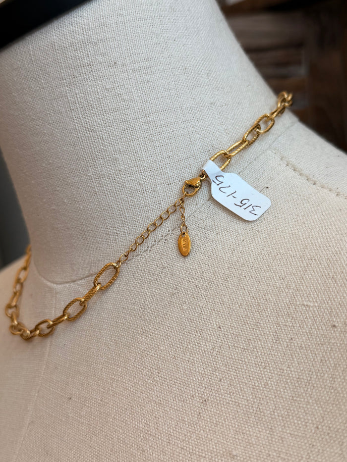 Gold-plated chain necklace close-up with oval links and a small hanging tag