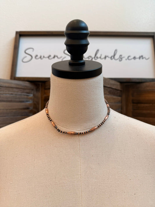 Copper torpedo bead necklace on mannequin bust with black and copper beaded strand
