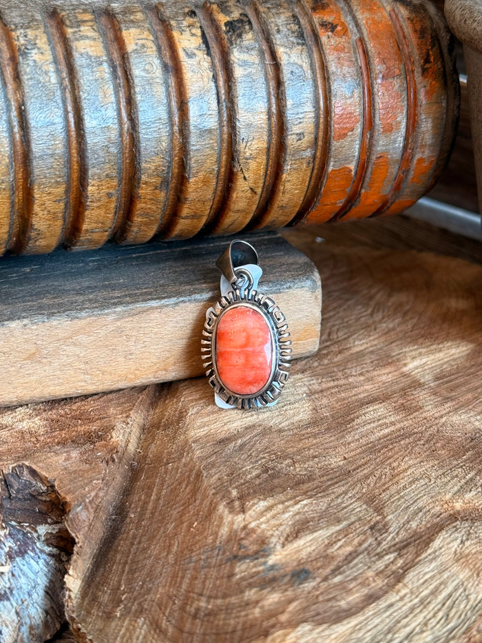 Small vintage pendant with oval orange stone and silver-tone spiny bezel