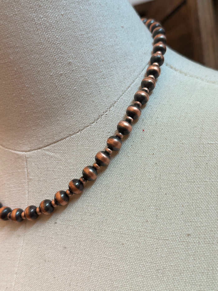 Close-up of 18-inch copper bead necklace with alternating large and small round beads