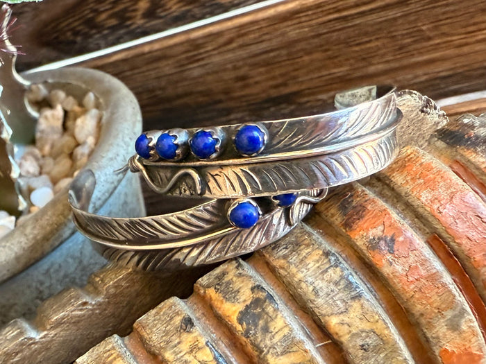 Feather drop earrings with blue lapis-style cabochons and etched feather detail