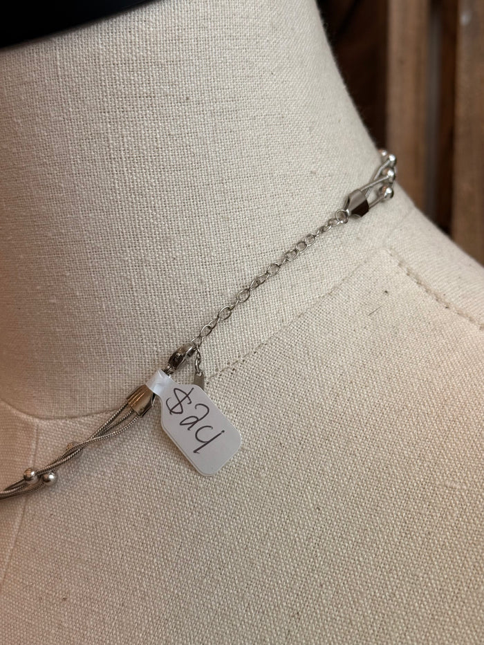 Stainless steel chain necklace with a small tag pendant and bead-accented links