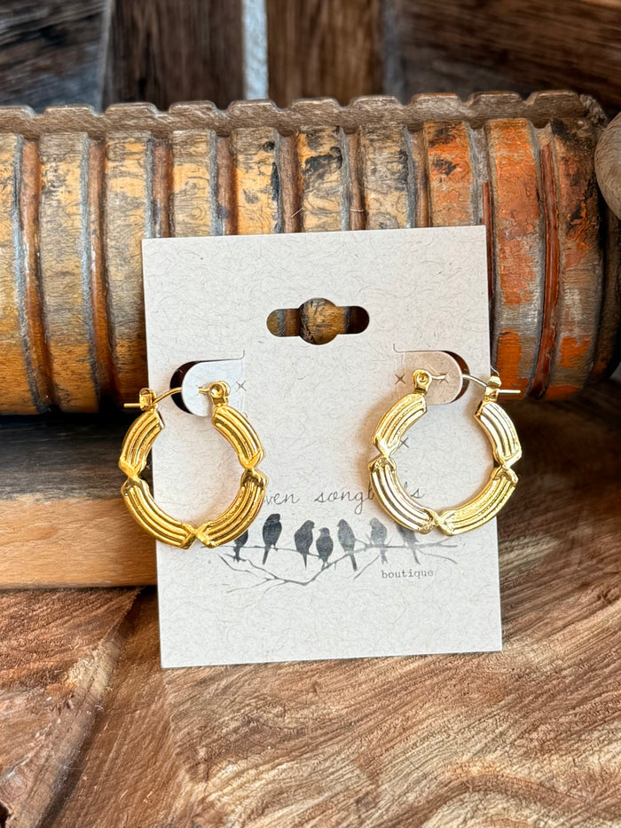 Textured gold hoop earrings with bamboo-like wire rings on white card
