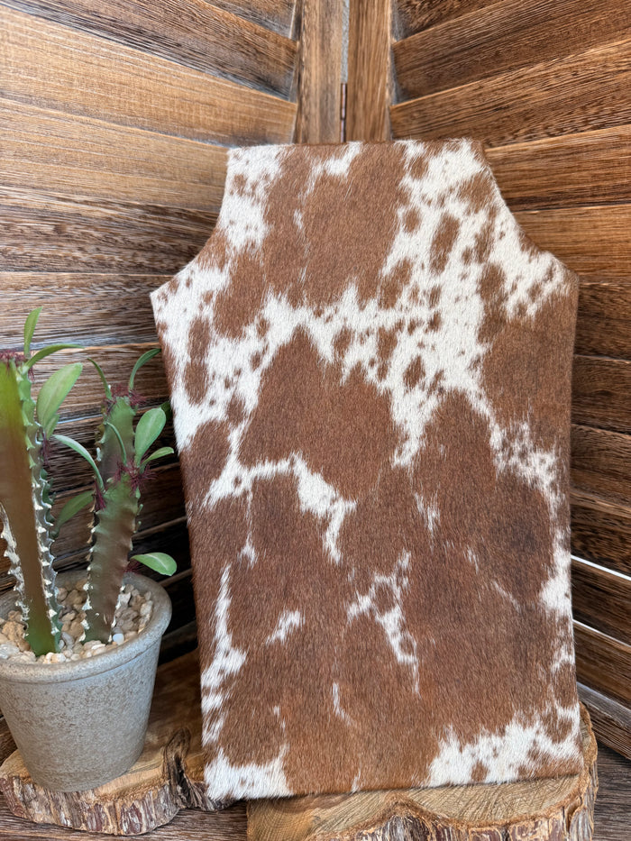 Cowhide necklace easel display in tan-and-white cowhide with clustered spots
