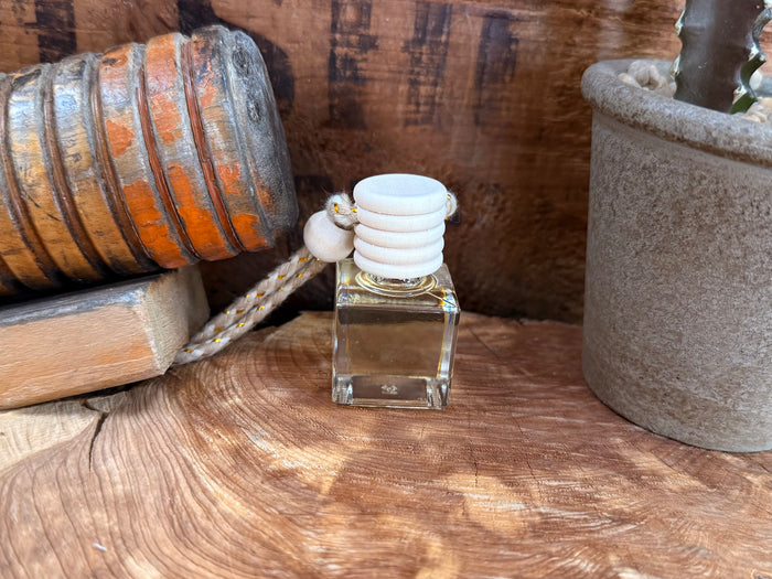 Glass car diffuser bottle with white stacked aroma pads and gold base, clear liquid