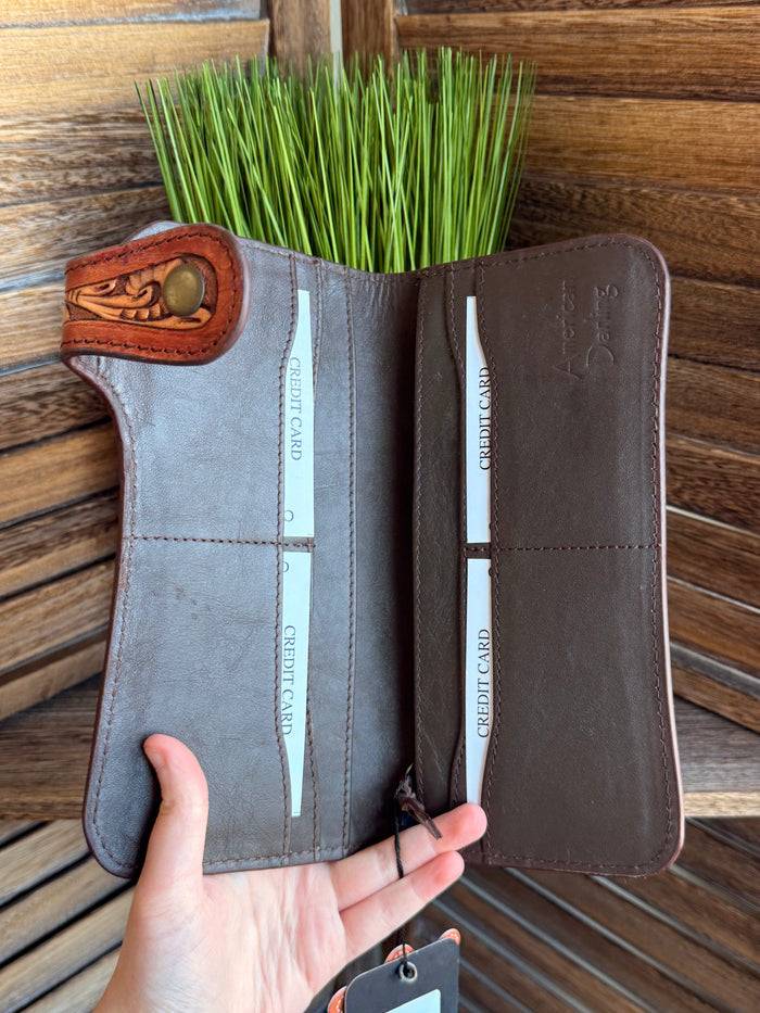 Tooled leather clutch wallet open inside view with card slots and dark lining.