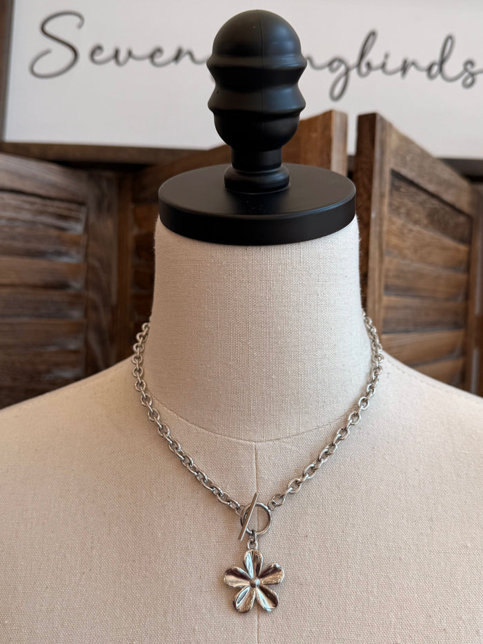 Silver daisy charm necklace with round toggle clasp and linked chain