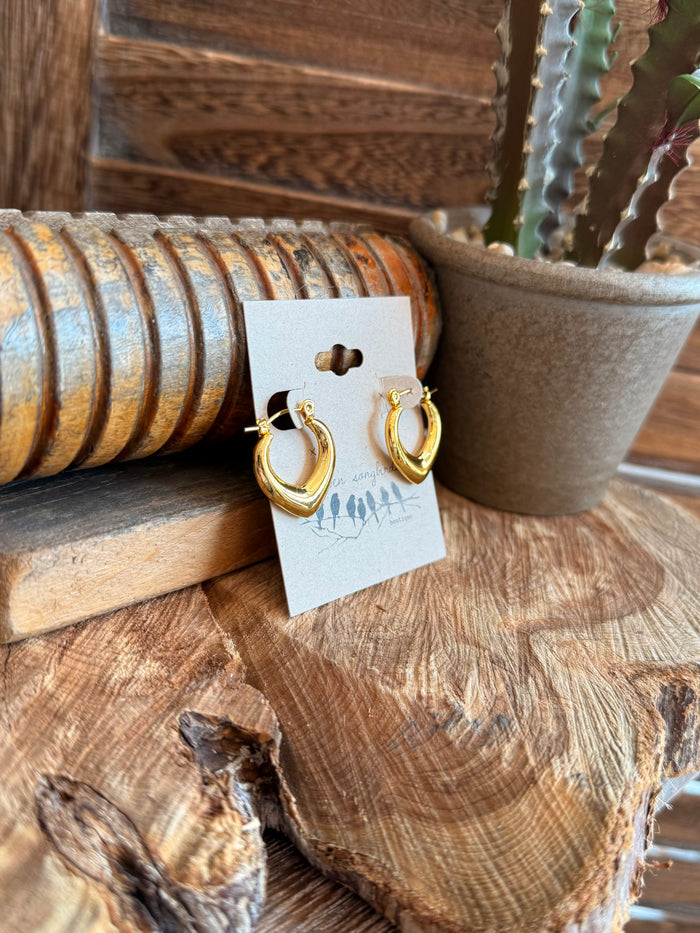 Gold-tone smooth half-hoop earrings with hinged closure, on a display card