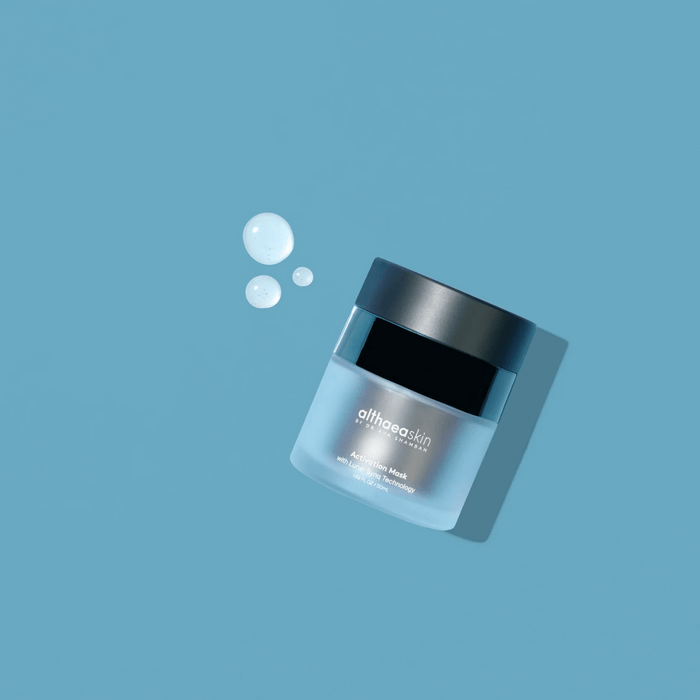Activation Mask | Althaea Skin jar with translucent blue gel droplets on a matching blue background, showcasing skincare product for hydration and rejuvenation.