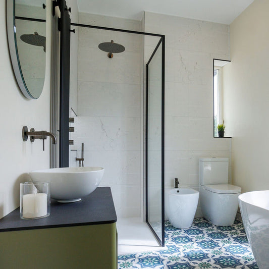 Modern bathroom with white wall tiles and patterned floor tiles.