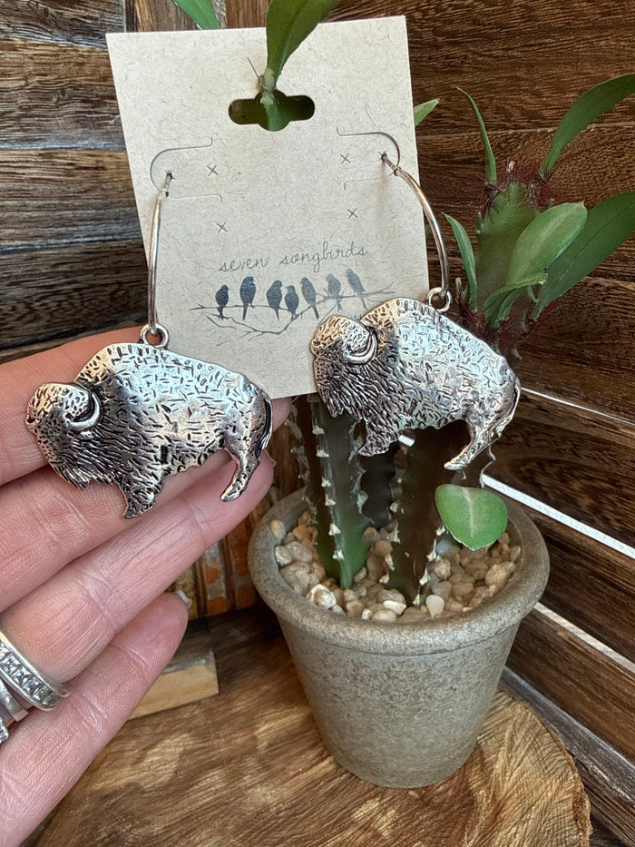Silver-tone buffalo drop earrings, pair shown on card with metal hook backs