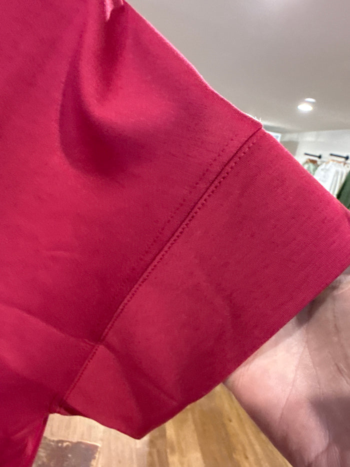 Burgundy T-shirt sleeve close-up with stitched seam and soft jersey knit
