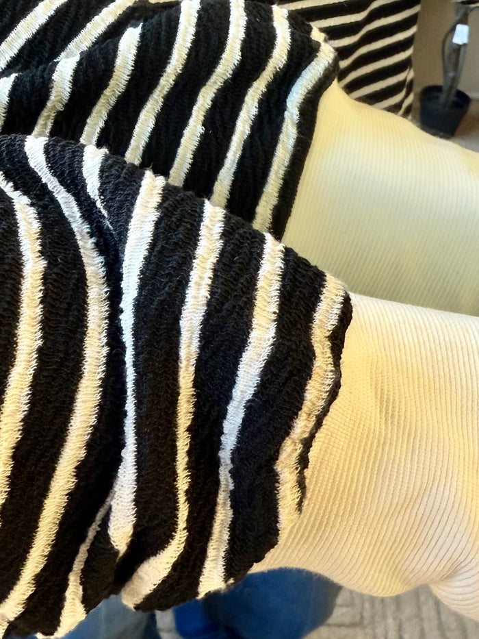 Long-sleeve polo sleeve with black and white vertical stripes and light ribbed cuff