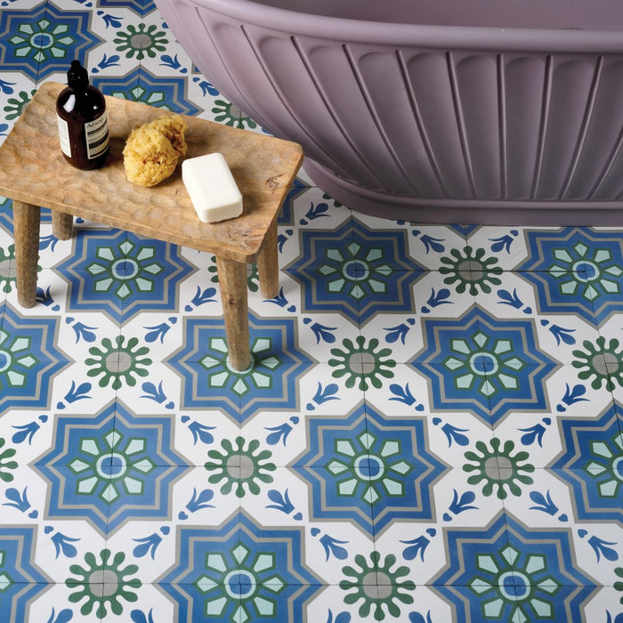 Decorative tiles with geometric patterns on a floor, with a wooden stool and purple bath