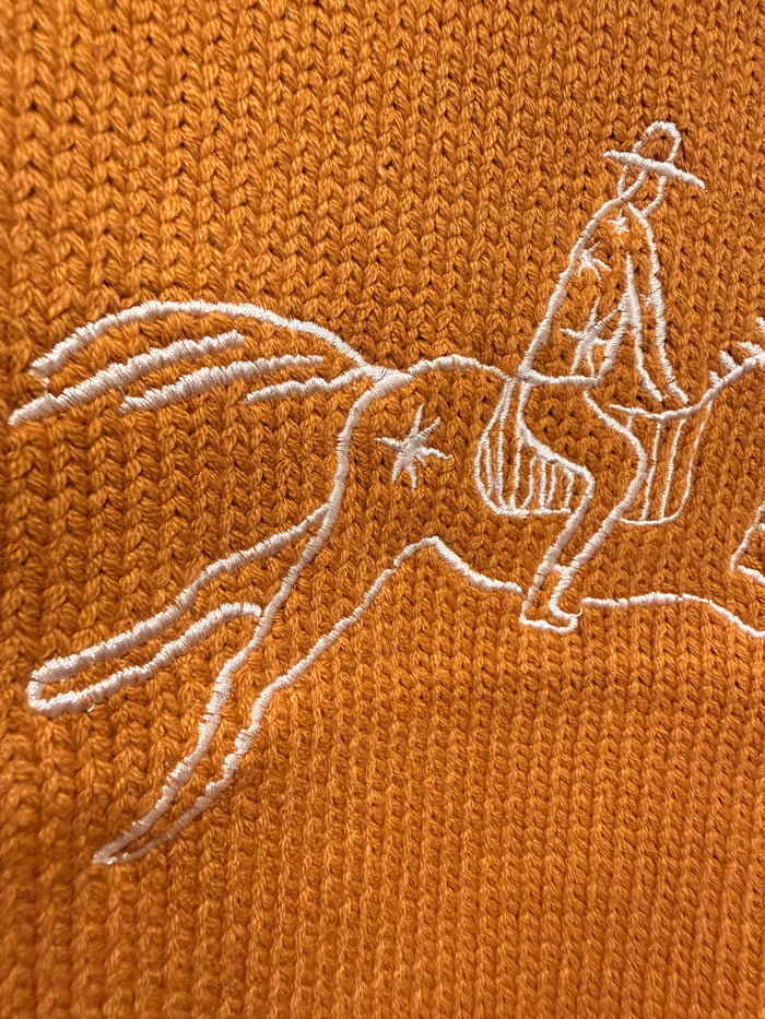 Rust sweater vest with white embroidered cowboy on horseback