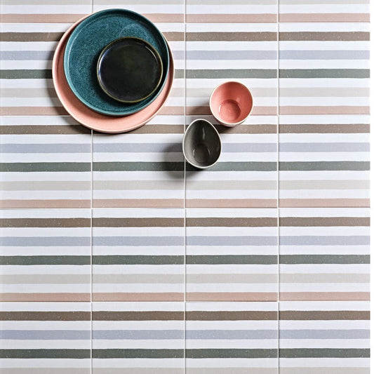 Colorrful ceramic bowls on striped tiles.