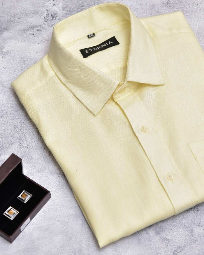 Men's butter yellow linen shirt with pointed collar and button-front, shown angled.