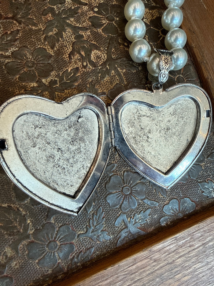 Heart locket pendant necklace with two silver-toned heart halves and pearl bead strand