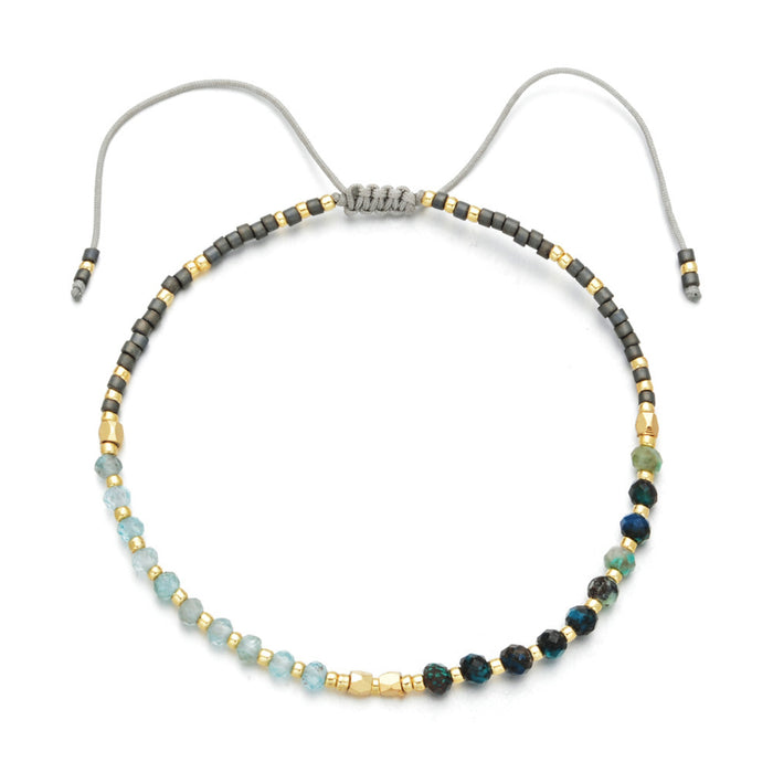 Japanese Handmade Bead Bracelets | Live Love Spa featuring a delicate mix of light blue, green, and dark beads with gold accents on an adjustable gray cord, symbolizing wellness and style.