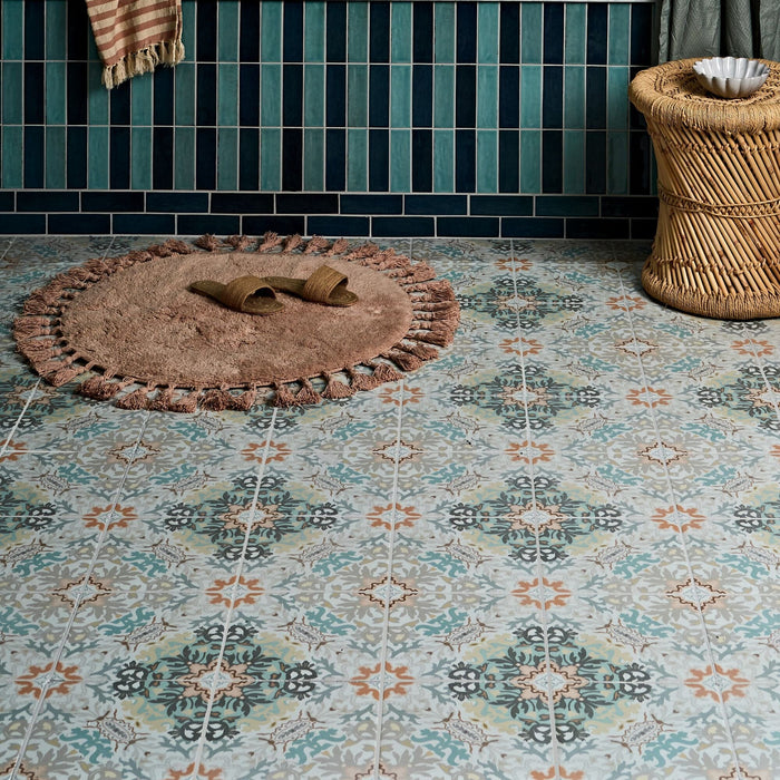 Patterned tile floor with a round bath mat and slippers in a bathroom setting.