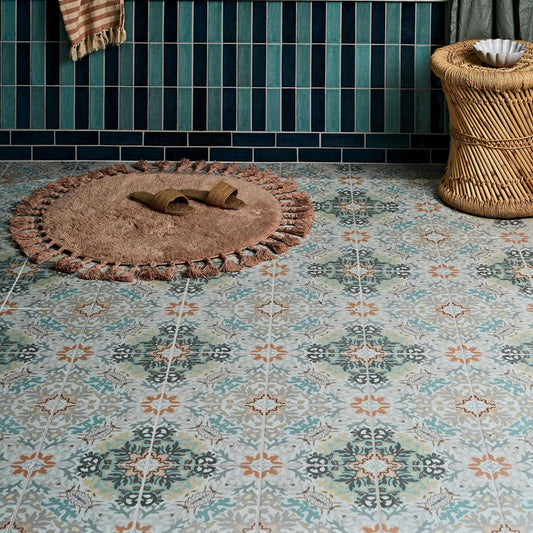 Patterned tile floor with a round bath mat and slippers in a bathroom setting.