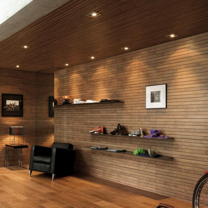 Modern interior with wood effect tiles on walls, shelves and a black armchair.