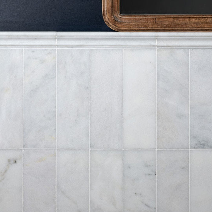 Close-up of marble tiles with a wooden frame in the top right corner.