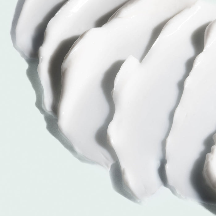 Close-up view of smooth white cream texture spread evenly, representing the skincare product MAX™ neck lift | IMAGE Skincare for wellness and body care.