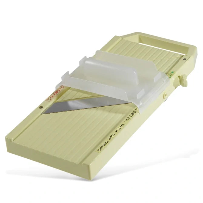 Green mandolin slicer on a white background