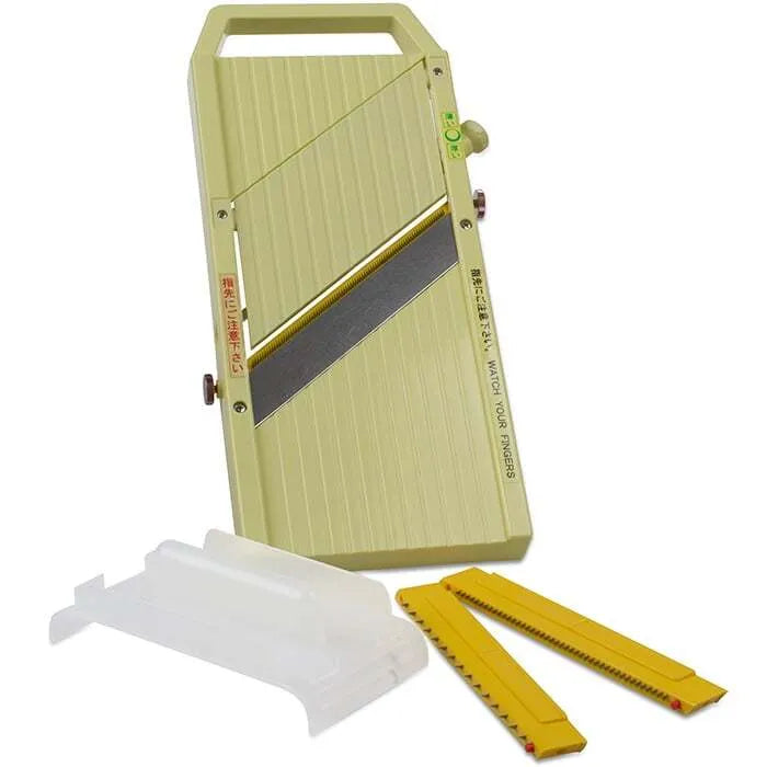Green mandolin slicer on a white background with 2 sized blades and handguard.