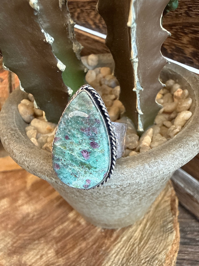Adjustable ring with oval teal stone in silver-toned bezel setting