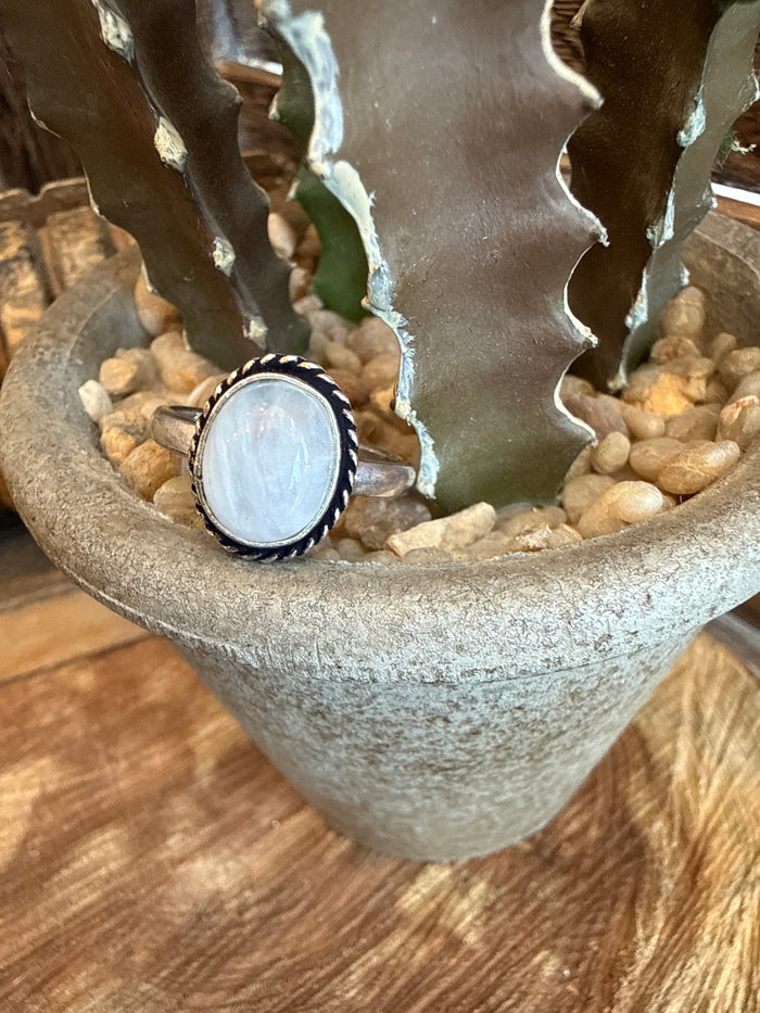 Adjustable brass ring with round light blue stone bezel and textured edge