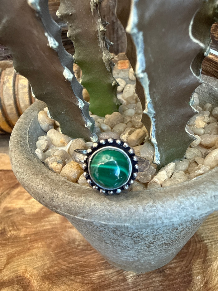 Adjustable brass ring with round green stone bezel and raised beaded border
