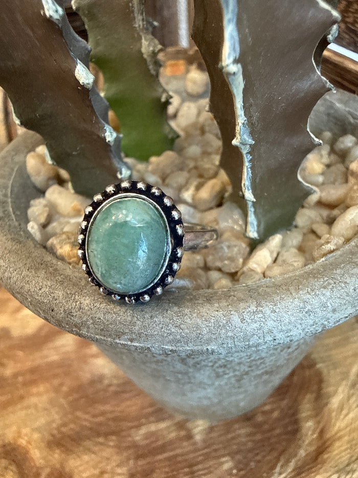 Adjustable brass ring with round teal stone bezel and dark beaded edging