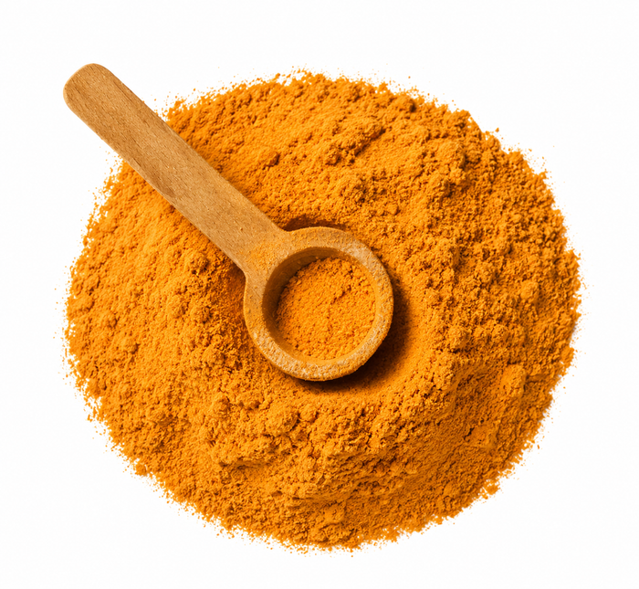 Wooden scoop in a pile of orange powder on a white background