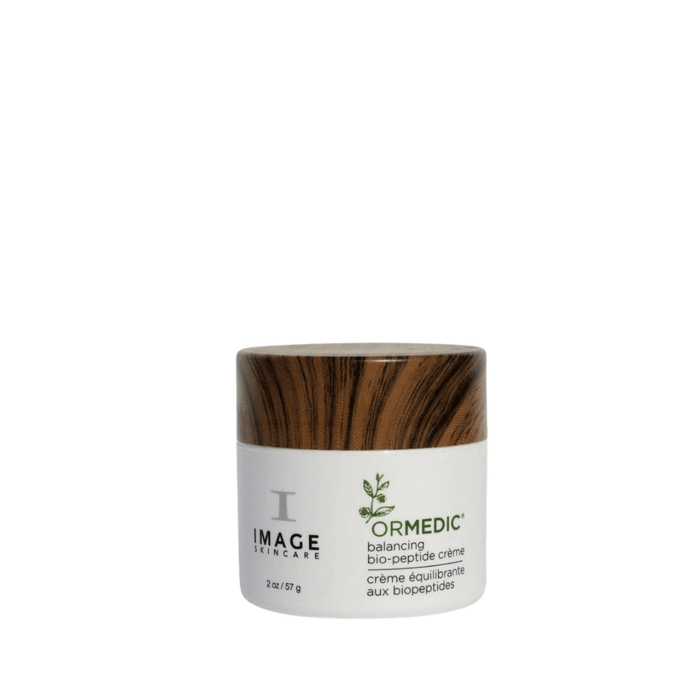 Jar of ORMEDIC balancing biopeptide crème | IMAGE Skincare with a white container and wood-textured lid, designed for skincare and wellness routines.