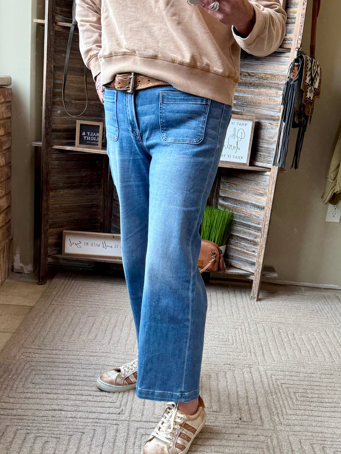 Front view of blue cropped jeans with patch pockets and belt loops
