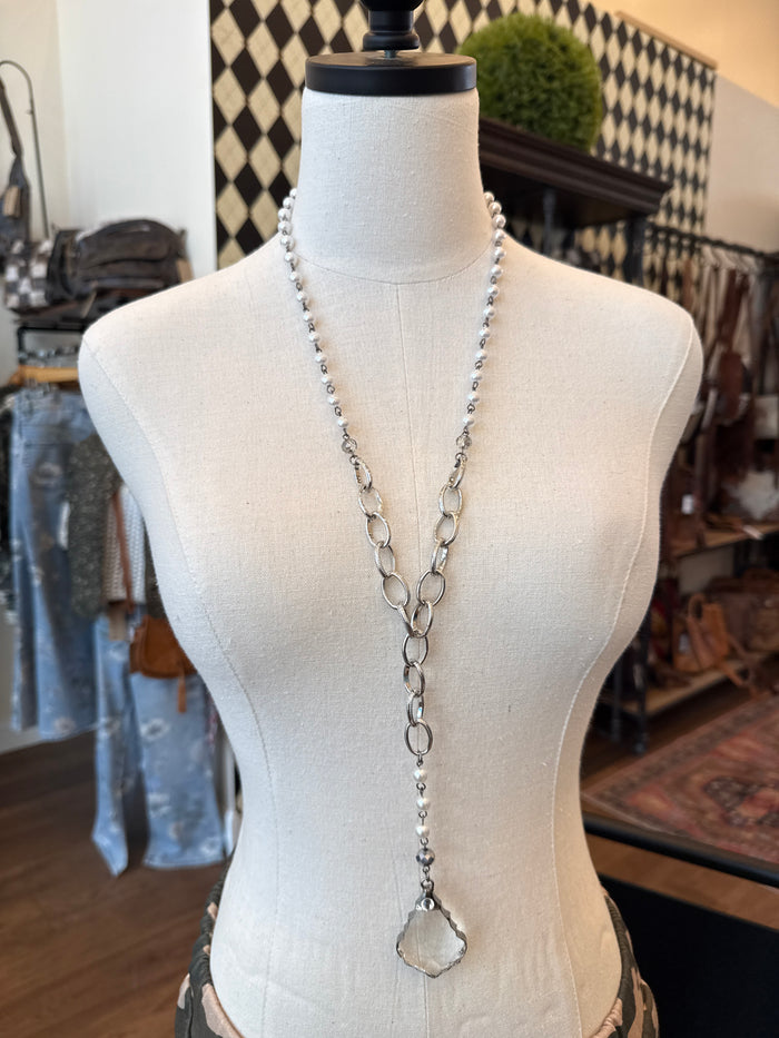 Silver-tone pearl and crystal pendant necklace on mannequin, teardrop pearl center