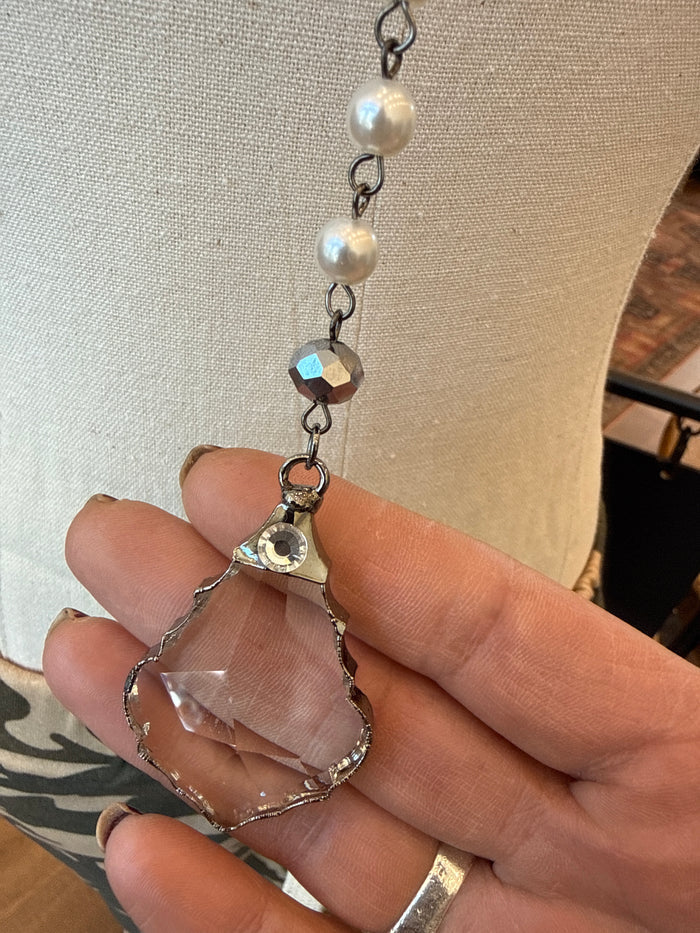 Silver-tone chain necklace with round pearls and faceted crystal charm, close-up