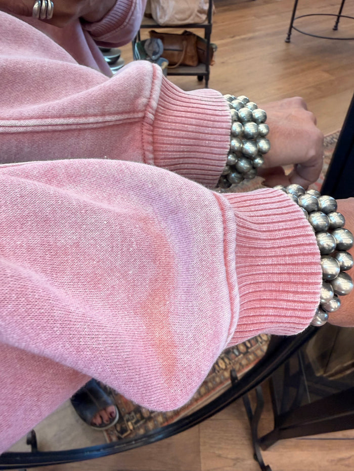 Pink quarter-zip sweatshirt cuff with ribbed knit texture