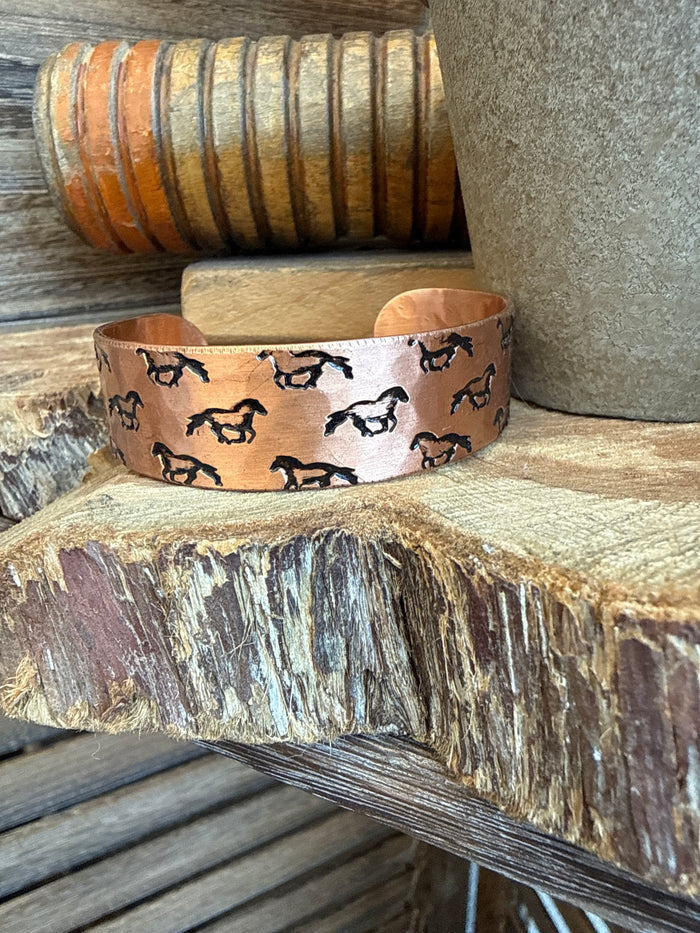 Copper cuff bracelet with black running horse silhouettes, wide center band