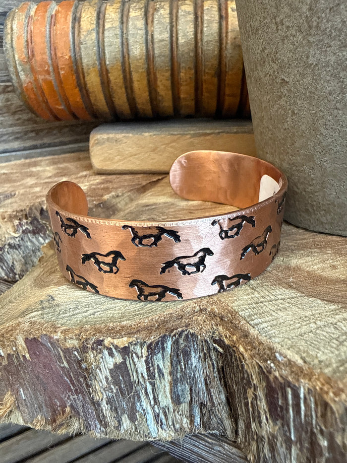 Copper cuff bracelet with repeating black horse icons, wide adjustable band