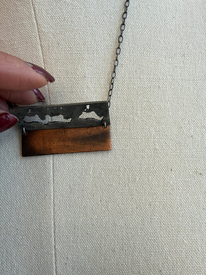 Small pewter-and-copper horses pendant held from a silver-tone chain