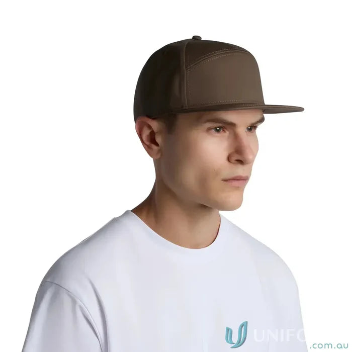 Man wearing a brown flat peak cap with plastic snapback and tonal under-peak lining