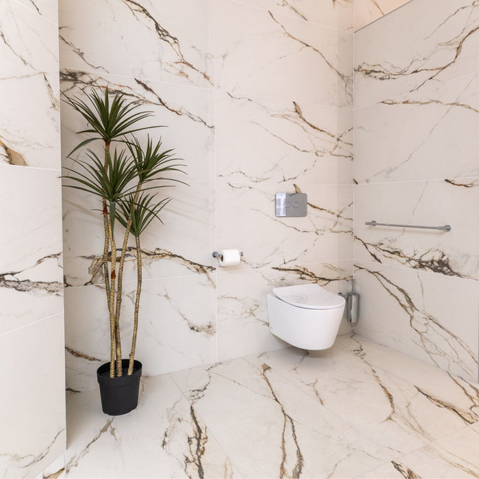 Bathroom with marble effect tiled walls, a plant and a toilet.