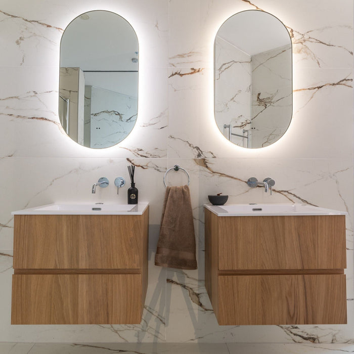 Bathroom with two wooden vanities, mirrors, and marble effect tiled walls