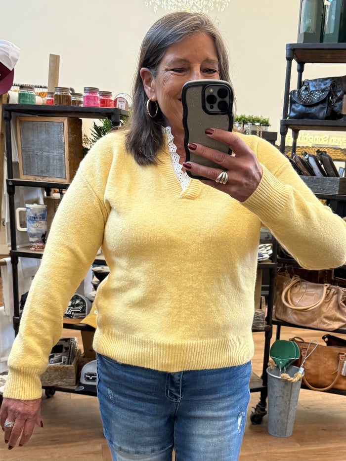 Yellow knit V-neck sweater with white lace trim at neckline